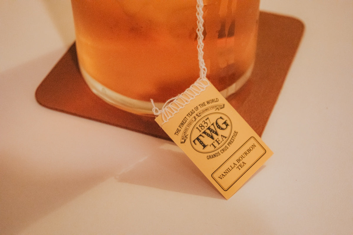 A glass of iced tea with a twg tea tag
